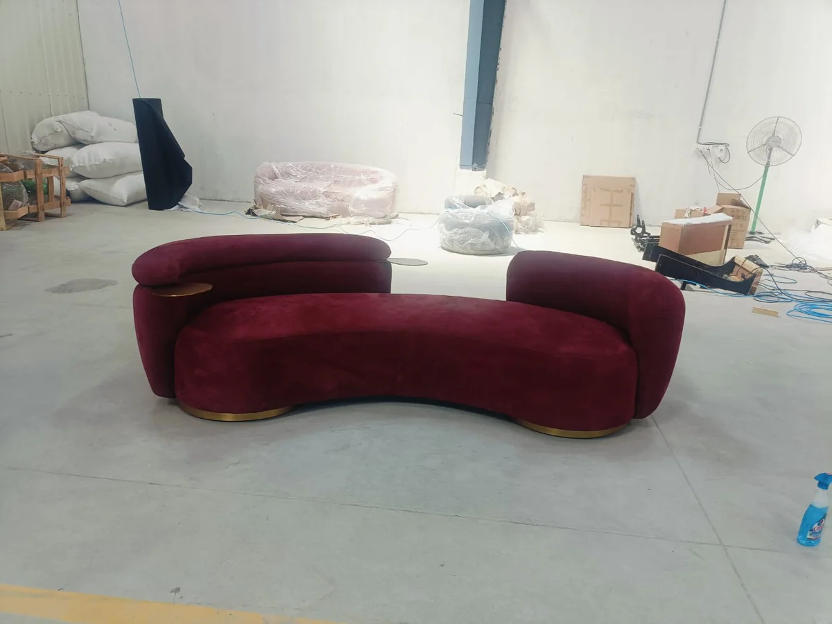 A burgundy velvet curved sofa of this design, built and waiting on our factory floor