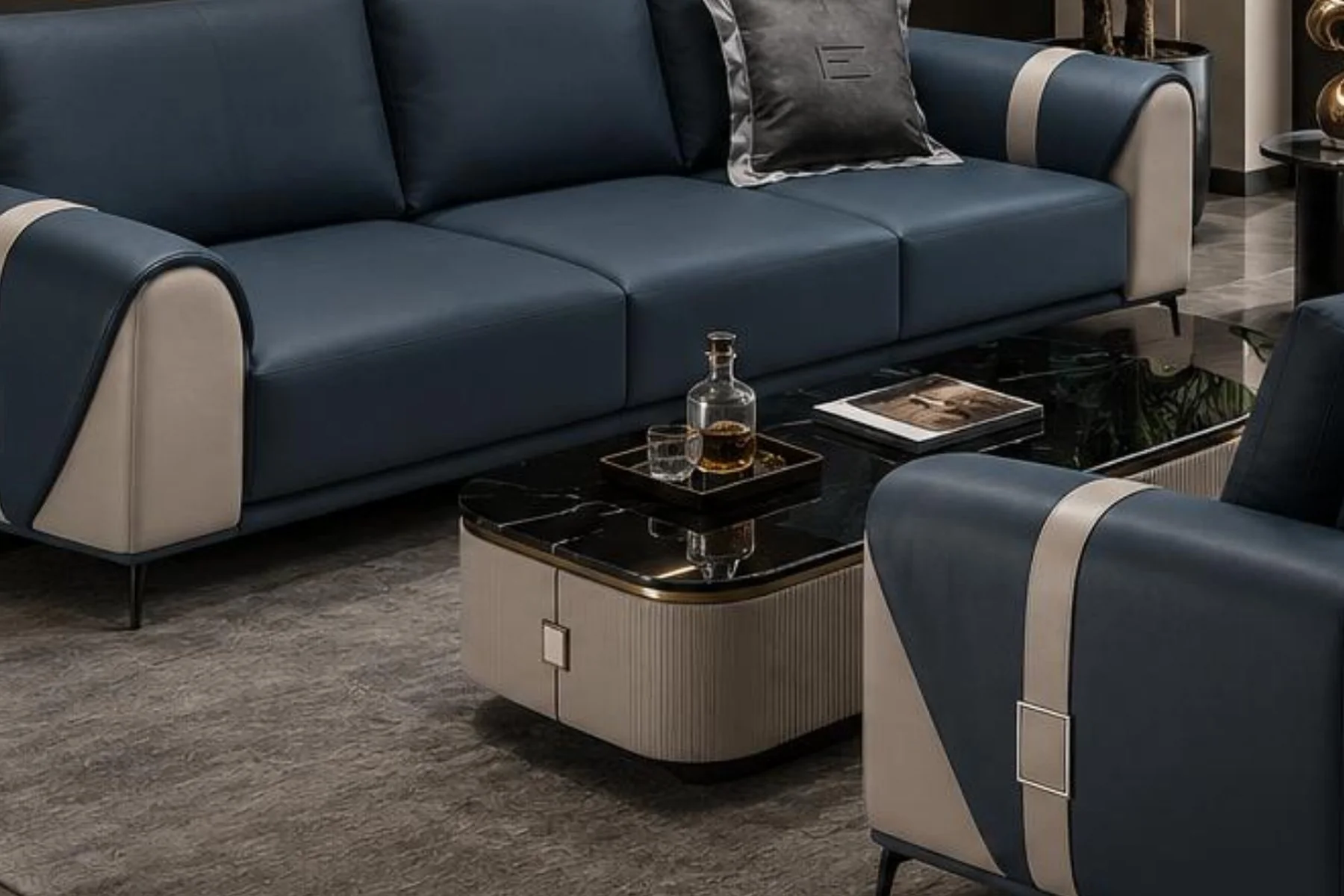 The Vento Luxe sofa set in navy and beige leatherette, a three-seater and a two-seater with a strap and buckle on each arm, around a low table