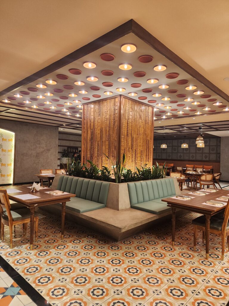 Stylish restaurant furniture by Mavensoft in a Hyderabad dining space, with cane-back chairs and wood table on patterned tile flooring.